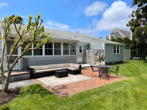 a patio with a couch and a table in a yard at 3 Shore Road Extension West Harwich Cape Cod - - A Shore Thing in West Harwich