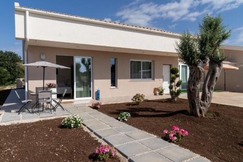 a house with a patio and a table and an umbrella at Nni Mia in Modica