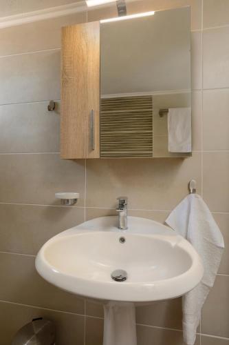 a bathroom with a white sink and a mirror at Elena Hara in Alikanas