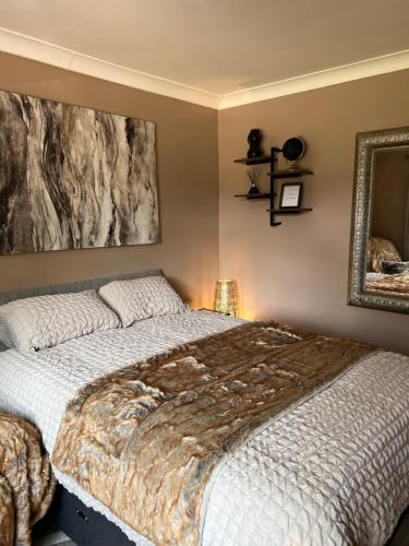 a bedroom with a large bed and a mirror at Cherry blossom lodge in Marton