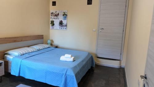 ein Schlafzimmer mit einem blauen Bett und einem Handtuch darauf in der Unterkunft Casa Cindy in Lamezia Terme