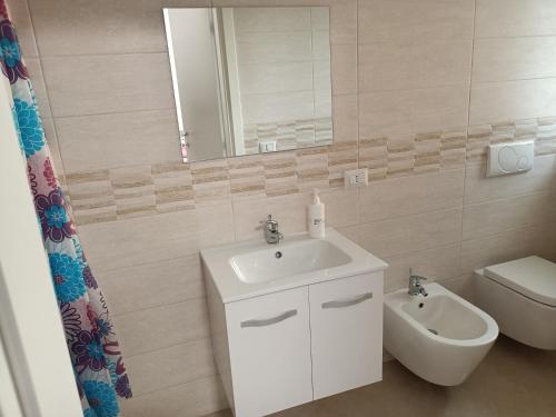 モンテスカリオーゾにあるPuccini Houseのバスルーム(洗面台、トイレ、鏡付)
