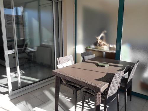 - une table à manger et des chaises dans une pièce avec fenêtre dans l'établissement Superbe Appartement FREJUS PLAGE, à Fréjus