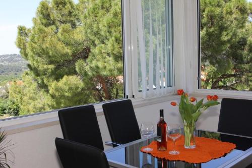 a dining room with a table and chairs and a window at Holiday House Pine Tree in Nerežišća