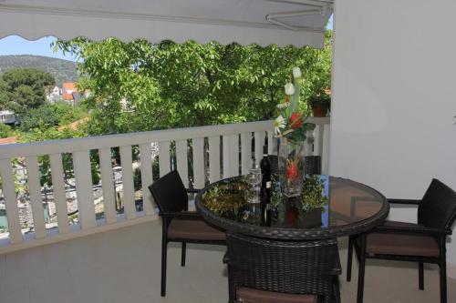 a table and chairs on a balcony with a view at Holiday House Pine Tree in Nerežišća