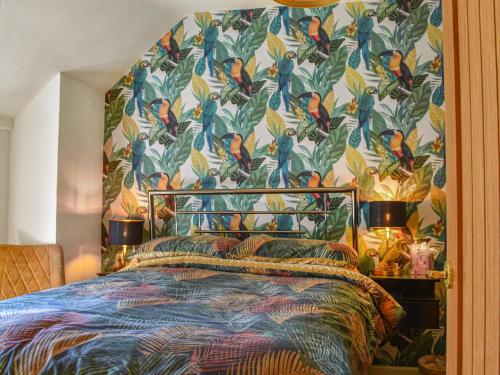 ein Schlafzimmer mit einem Bett mit Vogeltapete in der Unterkunft Willow Tree Cottage in Hayle