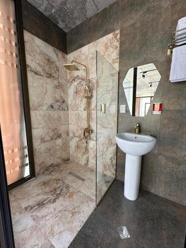 a bathroom with a sink and a shower at Hotel NOA Kazbegi in Stepantsminda