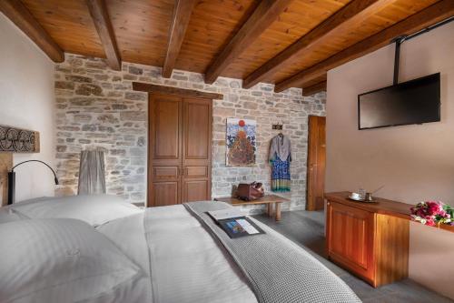 a bedroom with a bed and a flat screen tv at Sakali Mansion in Pinakátai