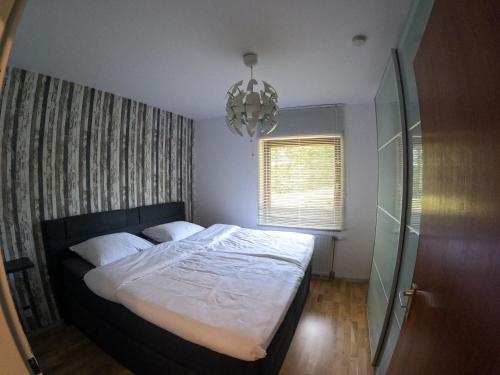Schlafzimmer mit einem Bett und einem Kronleuchter in der Unterkunft Moderne 3 Zi Ferienwohnung in Winterberg