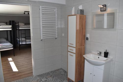 a white bathroom with a sink and a shower at Apartament Zacisze in Iława