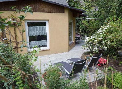 patio z krzesłami i stołem przed domem w obiekcie Ferienhaus-der-Villa-Elsa w Dreźnie
