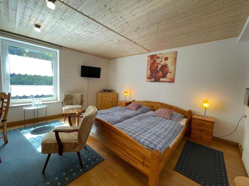 a bedroom with a bed and a chair and a window at Ferienhaus-der-Villa-Elsa in Dresden