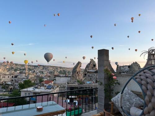 a view of a city with hot air balloons in the sky at Sunset Cave in Goreme