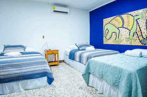 a bedroom with two beds and a painting on the wall at Hotel Boutique Mosaico in Granada