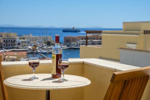 dos copas de vino sentadas en una mesa en un balcón en Ethrion, en Ermoupoli