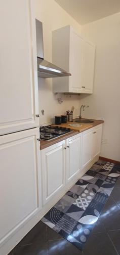 Una cocina con gabinetes blancos y un horno de estufa. en Las Mariposas, en Agrigento