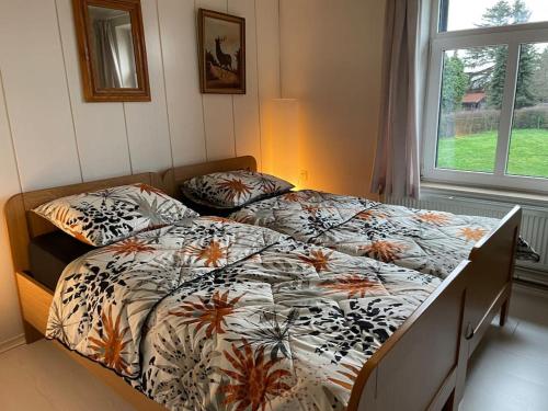 1 dormitorio con 2 camas y ventana en Charming authentic renovated farm, en Cadier en Keer