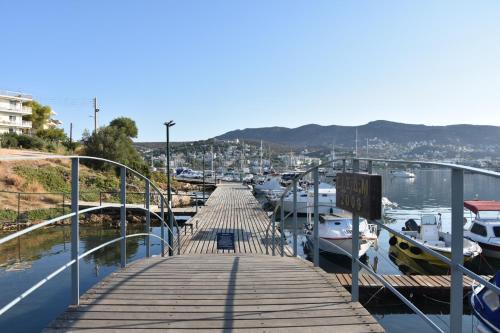 a wooden dock with boats docked in a marina at Homeyfeel Stay Sea 2 - Island mood studio in Porto Rafti