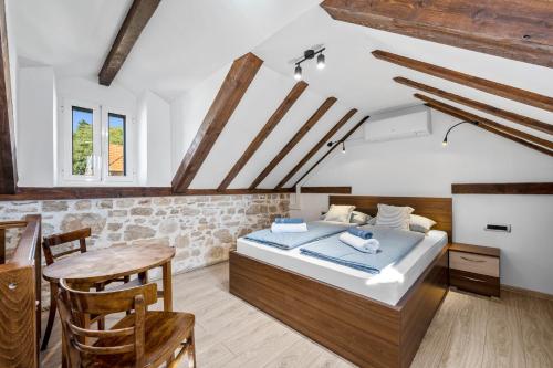 ズラリンにあるHouse AnaDora with pool - Zlarinのベッドとテーブルと椅子のある寝室