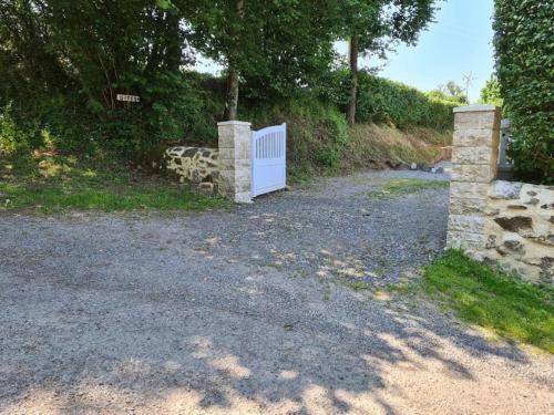 a driveway with a white gate and a stone wall at Millstone Gite 2, two bed apartment + shared pool in Chassenon