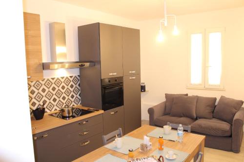 cocina y sala de estar con sofá y mesa en Appartamento Camelia, en Palo del Colle
