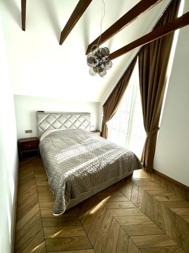 a bedroom with a bed and a large window at D&A Apartamentai in Palanga