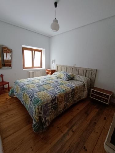 ein Schlafzimmer mit einem Bett und einem Holzboden in der Unterkunft VUT Corea324 in Caboalles de Abajo