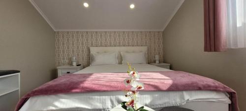 una camera da letto con un grande letto con una coperta rosa di Casa Leahu a Baile Unu Mai