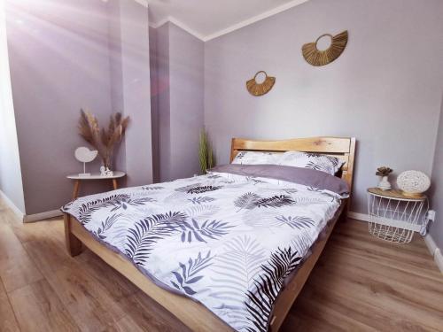 een slaapkamer met een bed met een zwart-wit dekbed bij Apartamenty Pszczew Krzysztof Michna Lubuskie Mazury Apartament "Natalia" in Pszczew