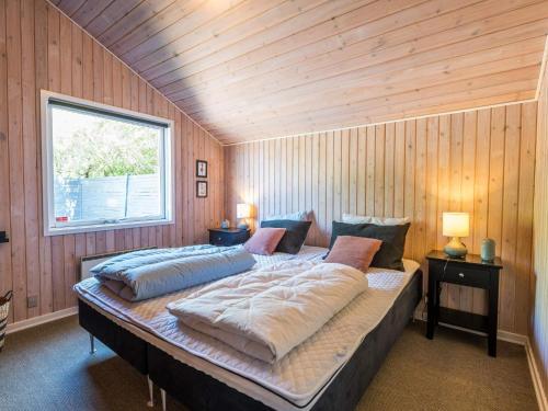 een slaapkamer met 2 bedden in een houten muur bij Holiday home Fanø CCVIII in Fanø