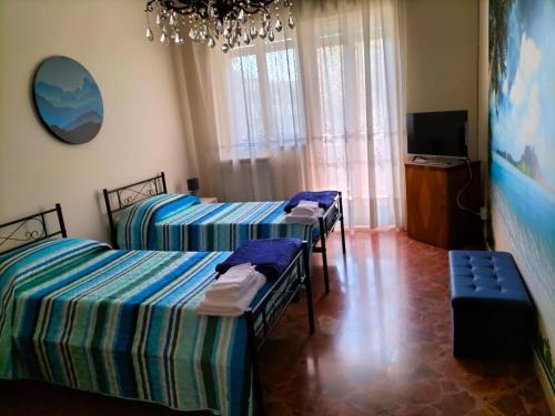 - une chambre avec 3 lits et une télévision dans l'établissement New Dawn Apartment, Appartamento Turistico, casa vacanze, à Catane