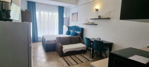 een slaapkamer met een bed, een stoel en een tafel bij Sky Studio in Constanţa