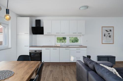 a kitchen and living room with a table and a couch at Number One Apartments in Vir