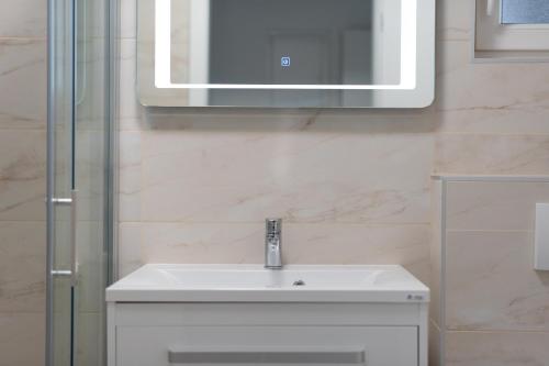 a bathroom with a white sink and a mirror at Number One Apartments in Vir