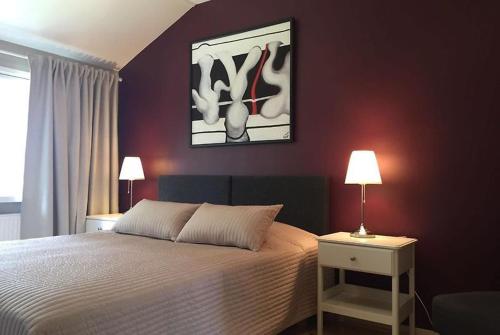 1 dormitorio con 1 cama y una pintura en la pared en Norppa Resort, en Savonlinna