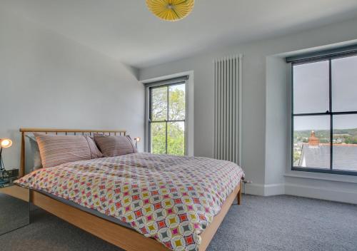 een slaapkamer met een bed en 2 ramen bij Bath Cottage in Saundersfoot