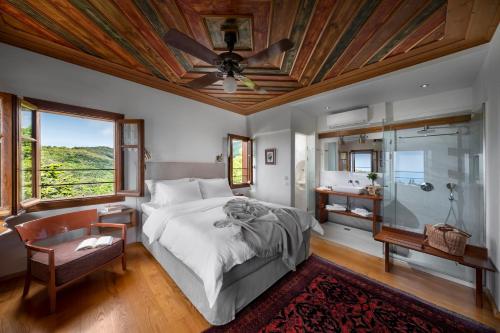 a bedroom with a bed and a ceiling fan at Sakali Mansion in Pinakátai