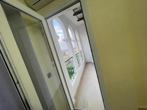 a glass door with a view of a balcony at Appartement de vacances piscines et plage in Tangier