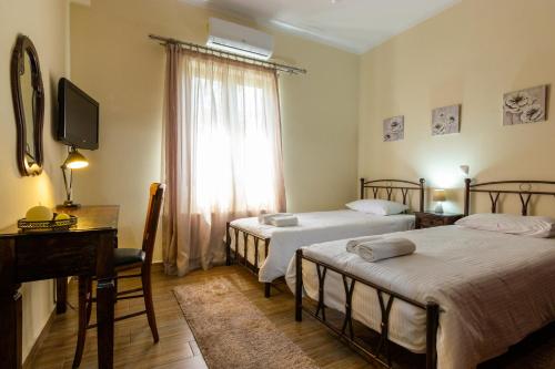 1 Schlafzimmer mit 2 Betten, einem Klavier und einem Fenster in der Unterkunft Katerina & Elia's Family House in Leonidi