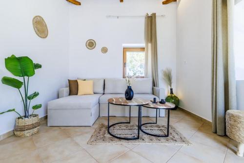 a living room with a couch and two tables at Villa Koukounaria in Skopelos Town