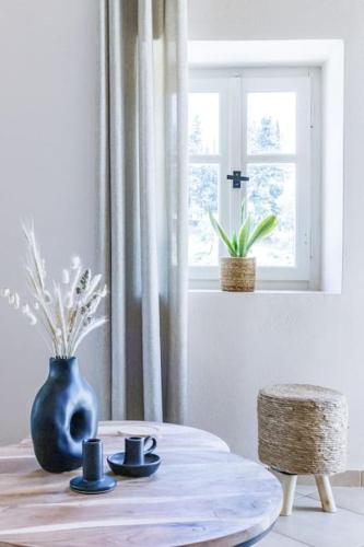 a room with a table with a vase and a window at Villa Koukounaria in Skopelos Town