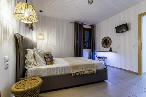 a bedroom with a bed and a chair and a chandelier at Villa Koukounaria in Skopelos Town