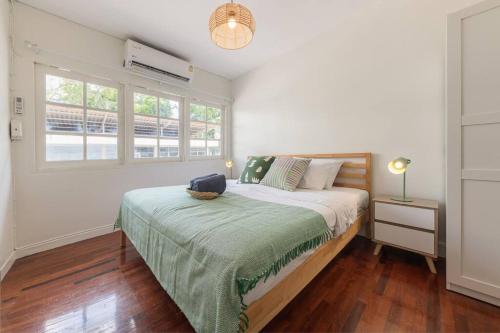 Oasis townhouse in the perfect location في بانكوك: غرفة نوم بسرير وبطانية خضراء