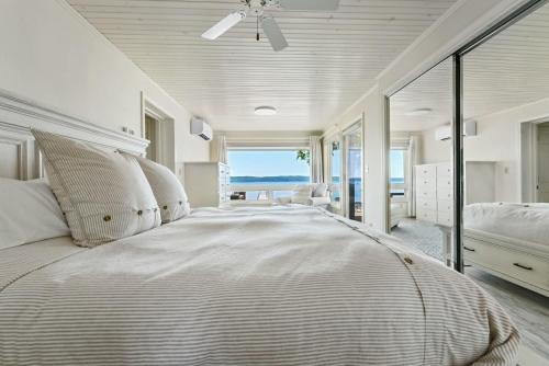 a bedroom with a large bed with a view of the ocean at Cloud Nine on Crystal Lake in Beulah