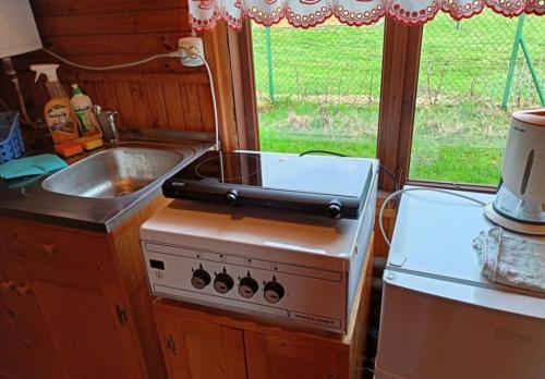 a small kitchen with a stove and a sink at Domek pod Brzózką in Ochotnica Górna