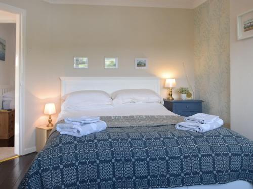 a bedroom with a bed with two towels on it at Ferry View in Cardigan