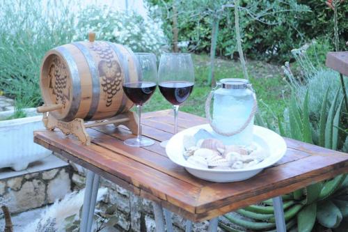 einen Tisch mit zwei Gläsern Wein und einer Vase in der Unterkunft Little house Kućica in Banjol