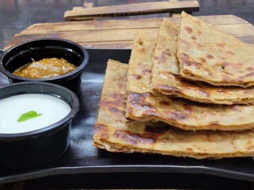 a black tray with a stack of tortillas and sauce at Dhairya's Villa Home Away From Home in Jammu