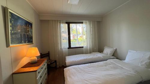 a hotel room with two beds and a window at Huoneisto karhujen kaupungissa - Tapanintien Lumo in Ähtäri
