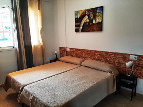 Un dormitorio con una cama y una pared de ladrillo. en Rosie House 2, en Parque Holandes